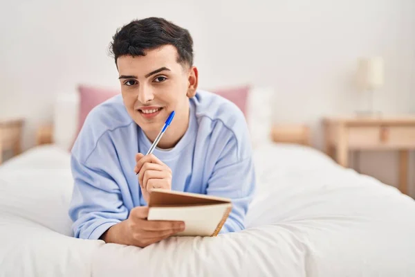 Young Non Binary Man Writing Notebook Lying Bed — Stock fotografie