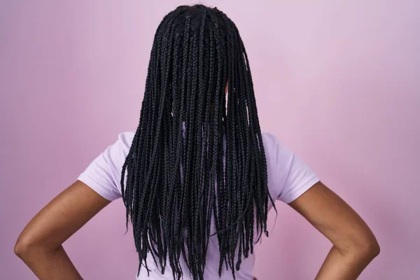 Африканська Американка Косами Стоять Над Рожевим Тлом Стоячи Позаду Дивлячись — стокове фото