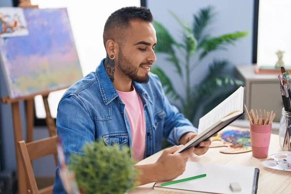 Young Hispanic Man Artist Reading Book Drawing Art Studio — Stock Photo, Image