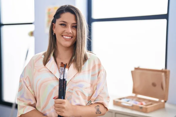 Young Hispanic Woman Artist Smiling Confident Holding Paintbrushes Art Studio — Photo