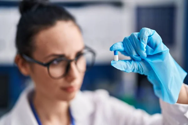 若い白人女性科学者が実験室で錠剤を保持 — ストック写真