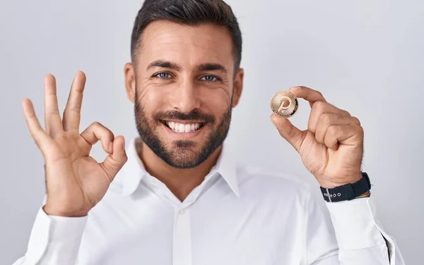 Handsome Hispanic Man Holding Polkadot Cryptocurrency Coin Doing Sign Fingers — Stock Photo, Image