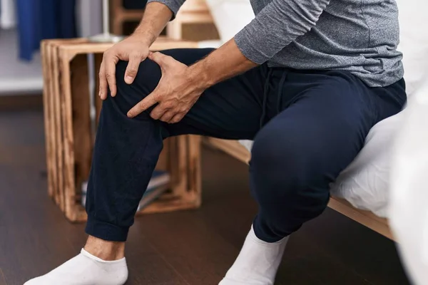 Young Hispanic Man Suffering Knee Injury Sitting Bed Bedroom — Fotografia de Stock