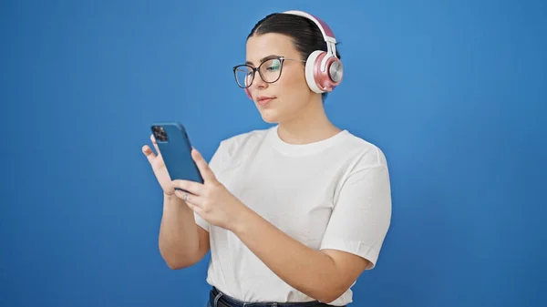 Young Beautiful Hispanic Woman Using Smartphone Wearing Headphones Isolated Blue — Stock Photo, Image