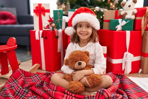 Adorable Hispanic Girl Hugging Teddy Bear Sitting Floor Christmas Tree — Stock Photo, Image