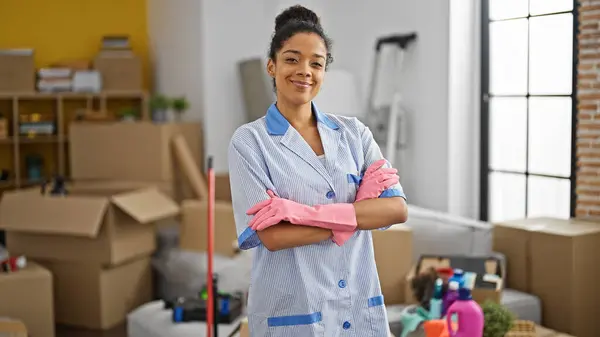 African american woman clean professional standing with arms crossed gesture smiling at new home