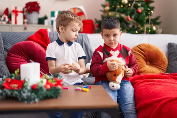 Çocuk Evdeki Noel Ağacının Yanında Kanepede Oyuncaklarla Oynuyor — Stok fotoğraf