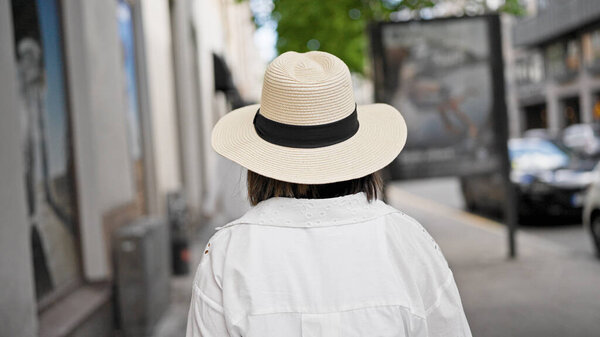 Beautiful young hispanic woman walking away in the streets of Stockholm