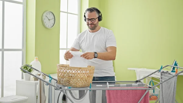 Grijsharige Man Luisterend Naar Muziek Hangend Kleding Aan Waslijn Wasruimte — Stockfoto