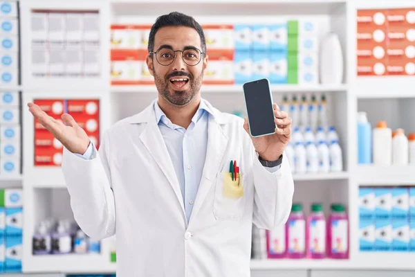 Hombre Hispano Con Barba Trabajando Farmacia Mostrando Pantalla Del Smartphone —  Fotos de Stock