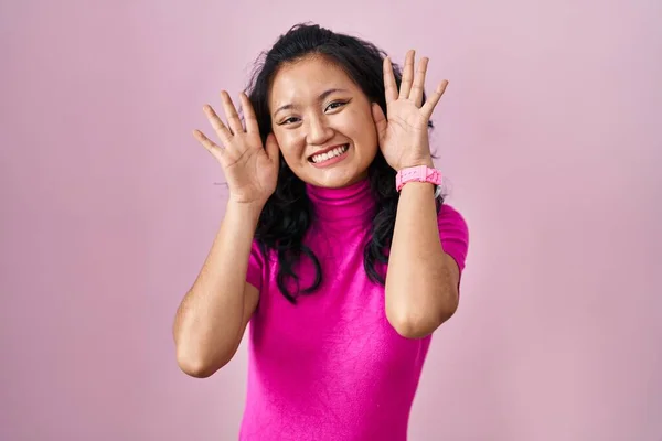 Young Asian Woman Standing Pink Background Smiling Cheerful Playing Peek — Stock fotografie