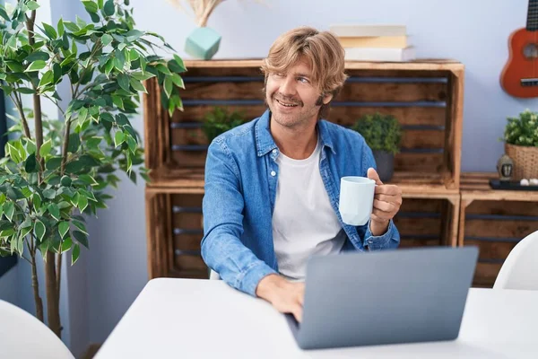 Genç Adam Dizüstü Bilgisayar Kullanıyor Evde Kahve Içiyor — Stok fotoğraf