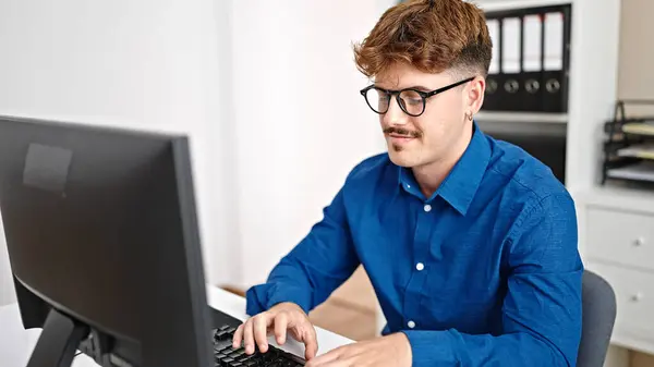 Young hispanic man business worker using computer smiling at the office