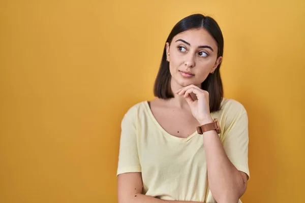 Chica Hispana Con Camiseta Casual Sobre Fondo Amarillo Con Mano — Foto de Stock