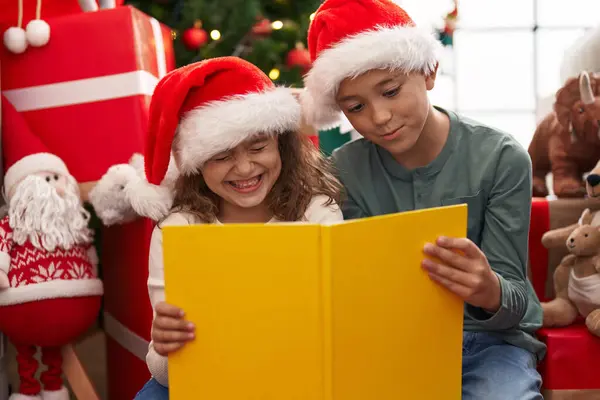 Kaksi Lasta Lukemassa Kirjaa Istuu Lattialla Joulukuusi Kotona — kuvapankkivalokuva
