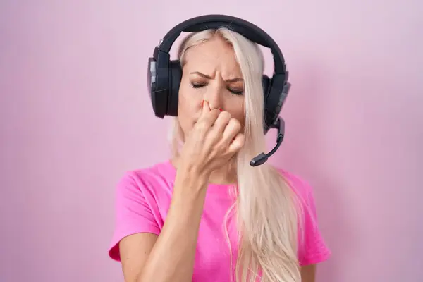 Mujer Caucásica Escuchando Música Usando Auriculares Oliendo Algo Apestoso Asqueroso — Foto de Stock
