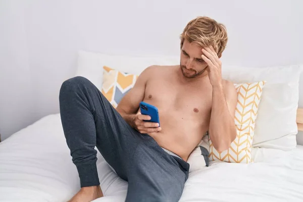 Young Man Using Smartphone Worried Expression Bedroom — 图库照片