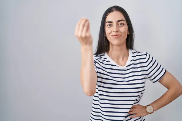 手と指自信の表現でイタリアのジェスチャーをするストライプTシャツを着ている若いブルネット女性 — ストック写真