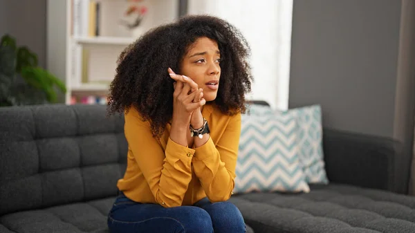 アフリカ系アメリカ人の女性が自宅でソファに座って強調 — ストック写真