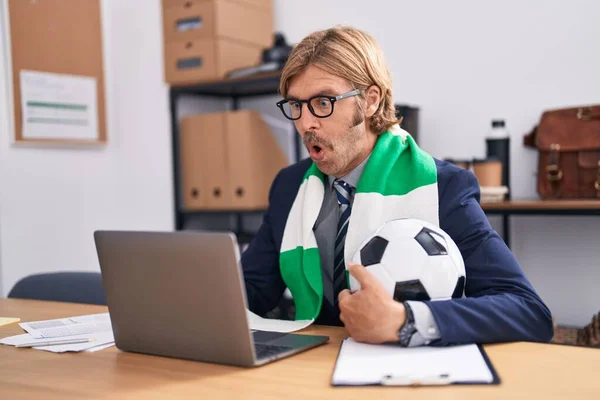 サッカーチームをサポートするオフィスで働く口ひげを持つ白人男性は 驚きのためのオープン口で驚きました 不信の顔 — ストック写真