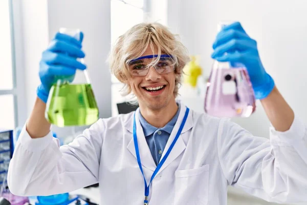 年轻的金发男子科学家在实验室拿着试管 — 图库照片