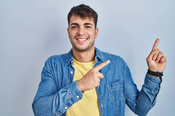 Young Hispanic Man Standing Blue Background Smiling Looking Camera Pointing — Stock Photo, Image