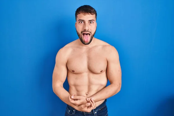 面白い表情で恥ずかしがり屋のヒスパニック系の男が恥ずかしそうに舌を突き出して立っている 感情の概念 — ストック写真