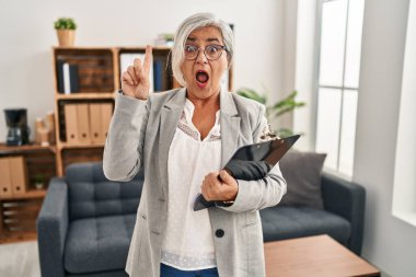 Muayenehanedeki gri saçlı orta yaşlı kadın başarılı bir fikri işaret ediyor. Heyecanlı ve mutlu. Bir numara.. 