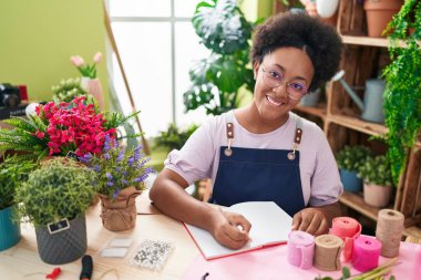 Çiçekçide kendine güvenen Afro-Amerikan kadın çiçekçi.