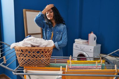 Çamaşır ipine elbise asan Asyalı genç bir kadın. Hatayla el ele tutuşup şaşırdı. Hatayı hatırla. Unuttum, kötü hafıza kavramı. 