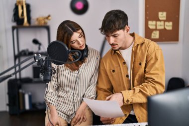 Mand and woman musicians singing song at music studio