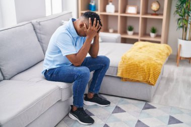 Evdeki kanepede oturan genç latin adam strese girdi.