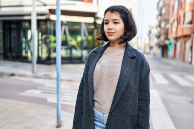 Young woman looking to the side with relaxed expression at street