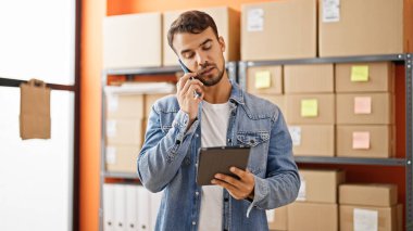 Young hispanic man ecommerce business worker smiling confident at office