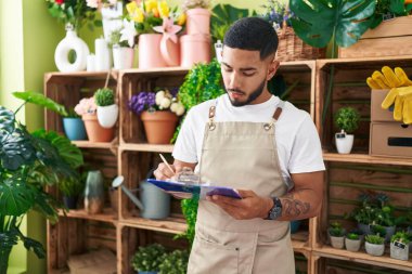 Çiçekçide döküman yazan Latin bir çiçekçi.