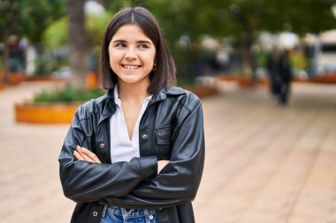 Parkta kollarını kavuşturmuş genç, güzel İspanyol bir kadın.