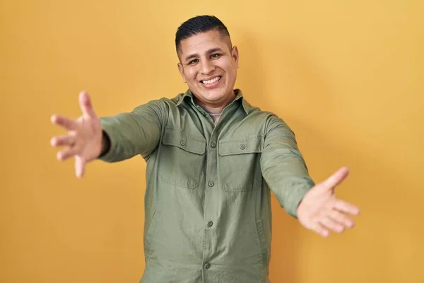 Jovem Hispânico Sobre Fundo Amarelo Sorrindo Alegre Oferecendo Mãos Dando — Fotografia de Stock