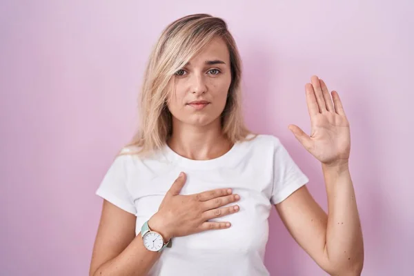 Young Blonde Woman Standing Pink Background Swearing Hand Chest Open — Stock Photo, Image
