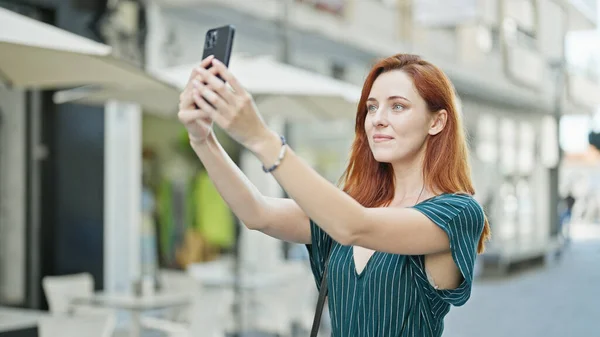 在咖啡店的露台上 红头发的年轻女子自信地在智能手机前自拍 — 图库照片