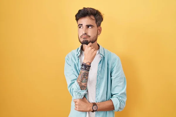Νεαρός Ισπανός Τατουάζ Που Στέκεται Πάνω Από Κίτρινο Φόντο Και — Φωτογραφία Αρχείου