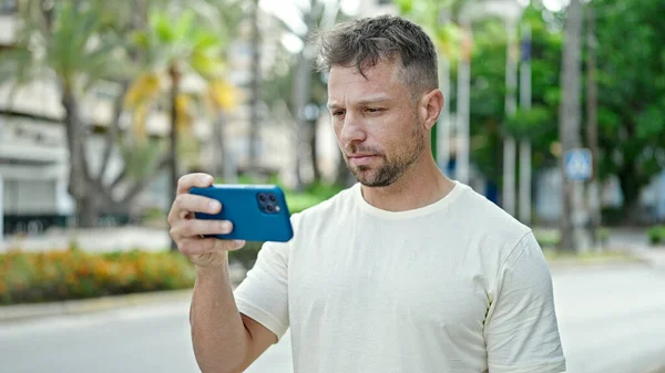 Junger Mann Benutzt Smartphone Mit Ernster Miene Park — Stockfoto