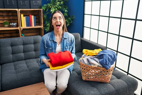 Hispanic Woman Holding Folded Laundry Ironing Angry Mad Screaming Frustrated — Stock Photo, Image