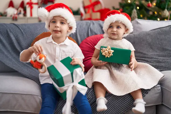Dvě Děti Drží Dárky Sedí Pohovce Vánočního Stromku Doma — Stock fotografie