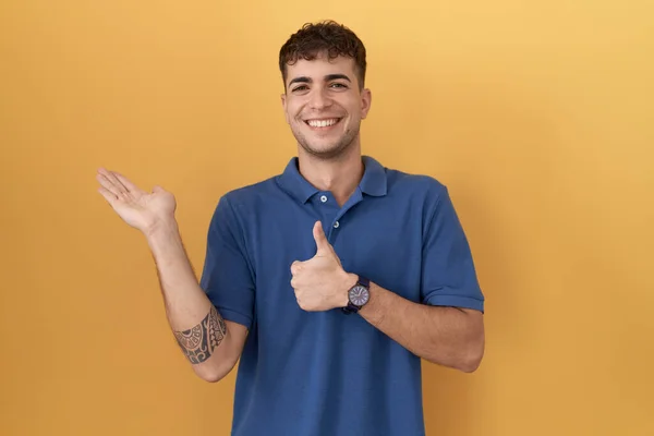 Young Hispanic Man Standing Yellow Background Showing Palm Hand Doing — 图库照片