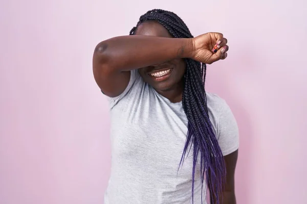 アフリカの若い女性は 陽気で面白い腕で目を覆うピンクの背景の上に立っています ブラインドコンセプト — ストック写真