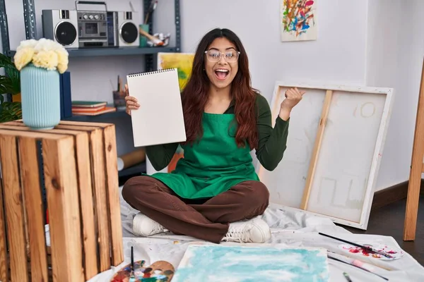 Mujer Joven Hispana Sosteniendo Cuaderno Estudio Arte Gritando Orgullosa Celebrando — Foto de Stock