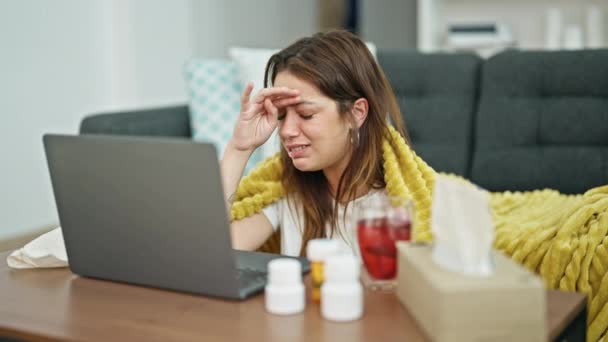 年轻美丽的惊慌失措的女人病坐在地板上 在家里用笔记本电脑进行在线医疗咨询 — 图库视频影像