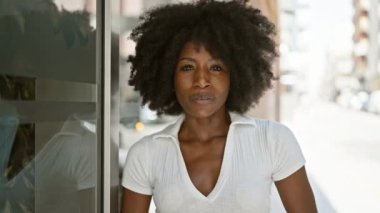 Afro-Amerikalı kadın gülümsüyor. Kendine güveniyor.