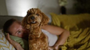 Köpekli beyaz bir kadın evdeki kanepede yatıyor.