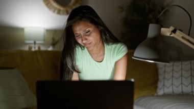 Evde görme problemi için dizüstü bilgisayar kullanan genç Latin kadın.